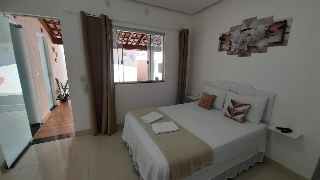 卡皮托利乌Pousada Jeitim Mineiro的一间卧室,卧室内配有一张大床