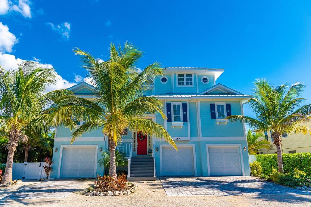 霍姆斯海滩Tiki Beach的一座棕榈树的蓝色房子