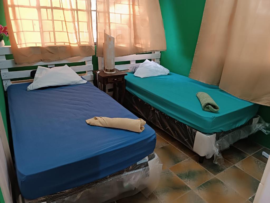 AhuachapánQuinta El Espino的两张睡床彼此相邻,位于一个房间里