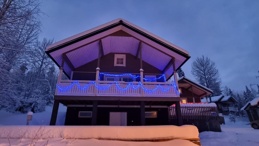 耶姆赛Villa Magnolia 2 Himos的雪中带紫色甲板的房子