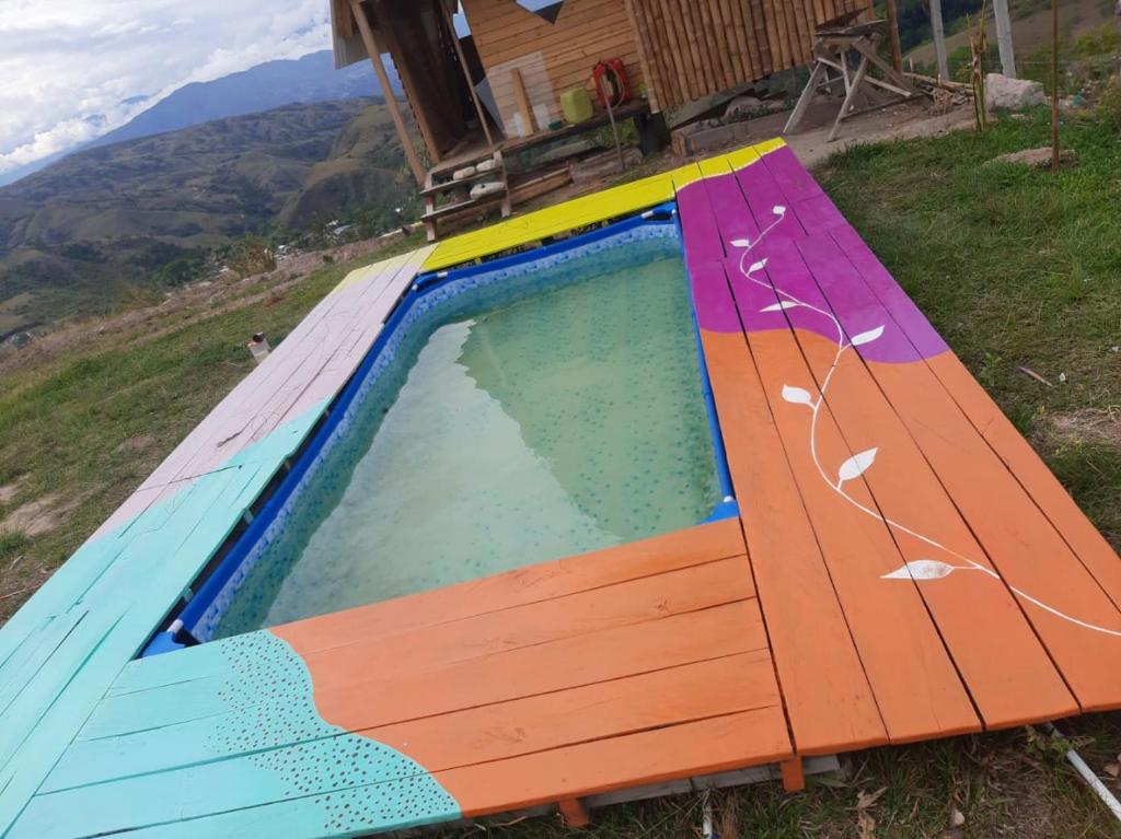 GiganteLos Nevados Ecolodge的房屋前设有木凳的游泳池