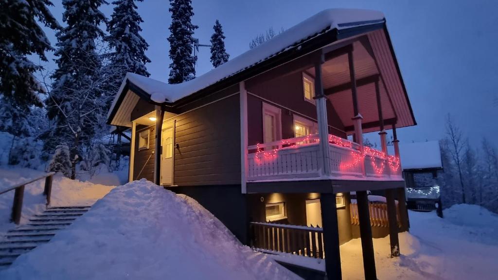耶姆赛Villa Magnolia 1 Himos的雪上小屋,阳台上配有圣诞灯