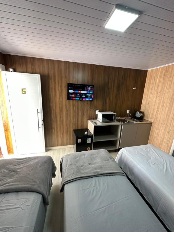 沙佩科Loft Lux 5的一间医院房间,配有两张床和一台墙上的电视