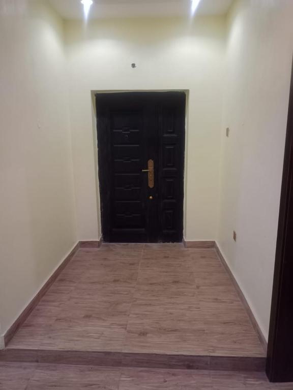 拉各斯Berkley House的白色客房的黑色门,铺有木地板