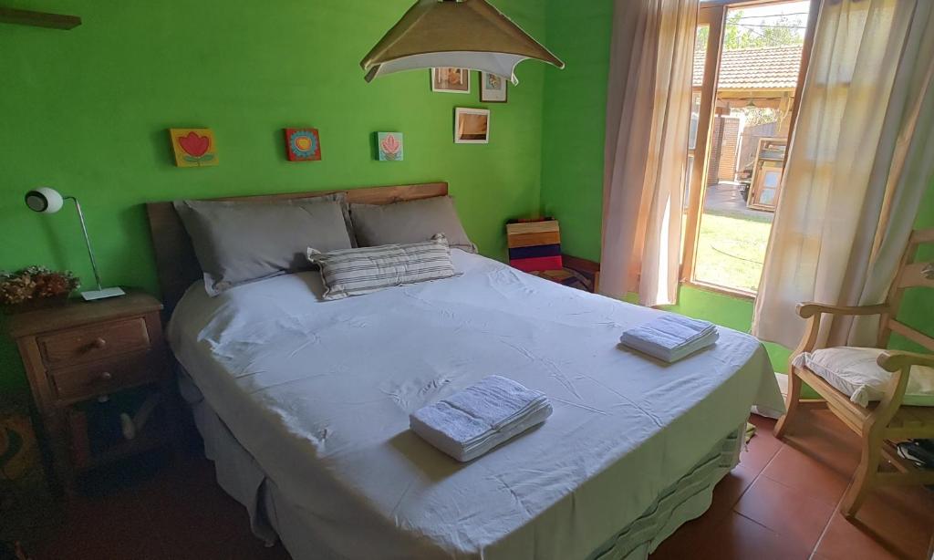 卢汉德库约Posada del. Huerto的一间卧室设有一张带绿色墙壁的大床