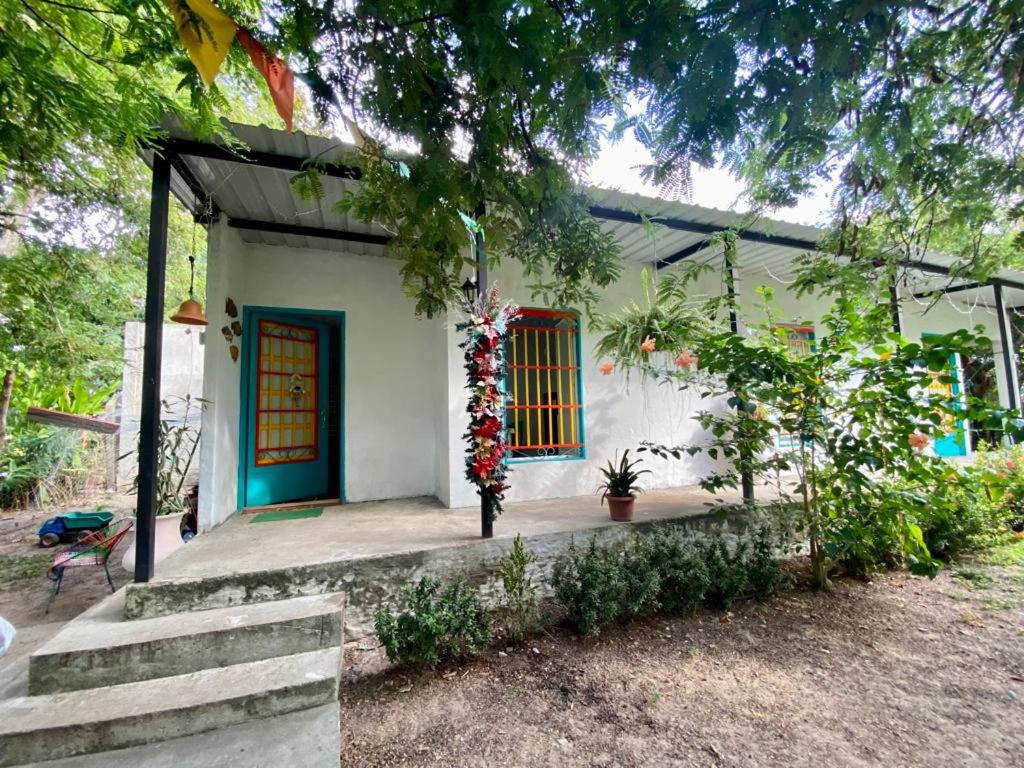 阿瓜奇卡Apartaestudio Villa Mary-Aguachica的一座有蓝色门和一棵树的房子