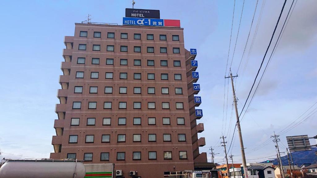 敦贺市Hotel Alpha-One Tsuruga的一座高大的建筑,上面有标志