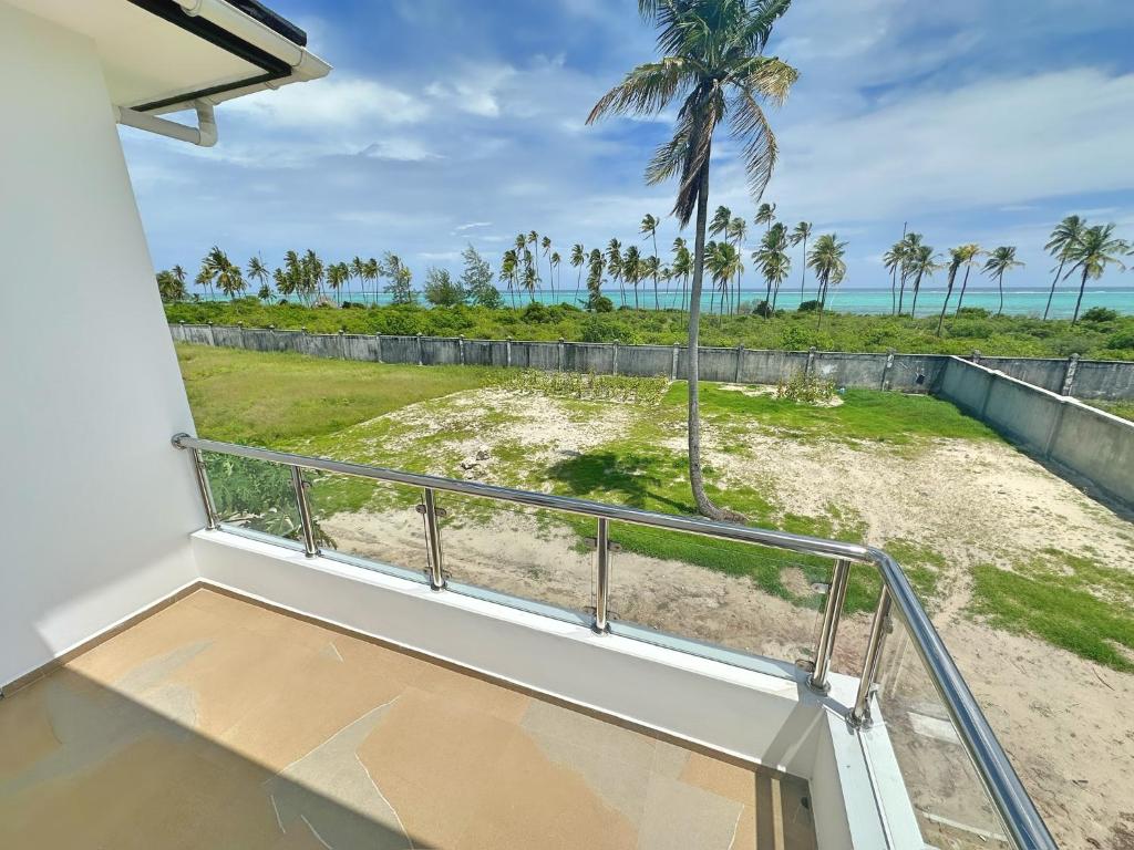 平圭Tropical Gem: 3-BR Beach Villa的享有海滩和棕榈树景致的阳台