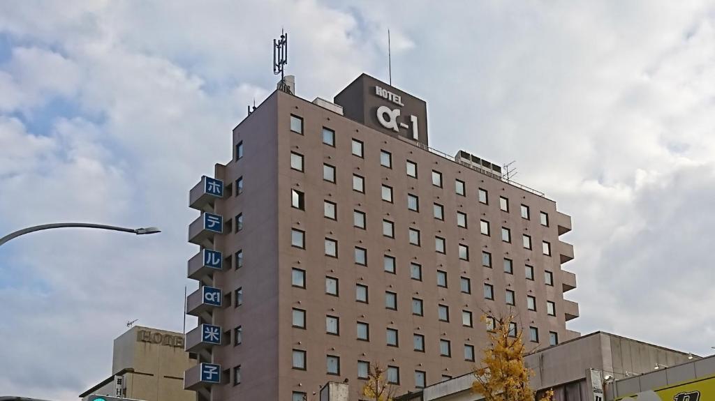 米子市Hotel Alpha-One Yonago的顶部有旗帜的建筑