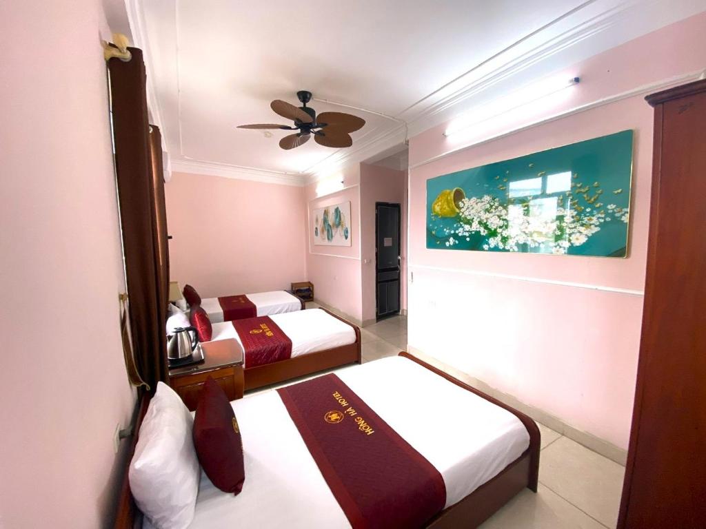 Thach LoiHong Ha Airport Hotel的一间卧室配有两张床和吊扇