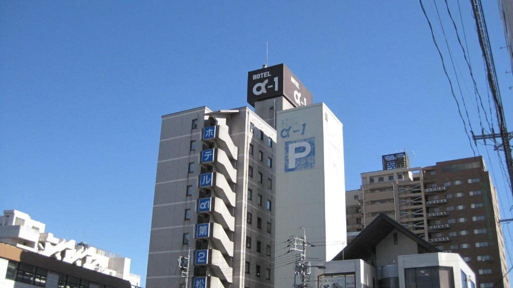 松江市Hotel Alpha-One Daini Matsue的一座高大的建筑,上面有标志