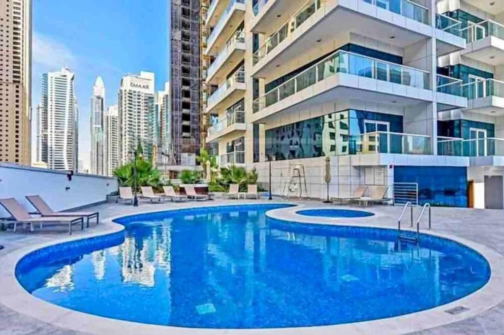 迪拜Lux High Rise Marina Apartment的大楼前的大型游泳池