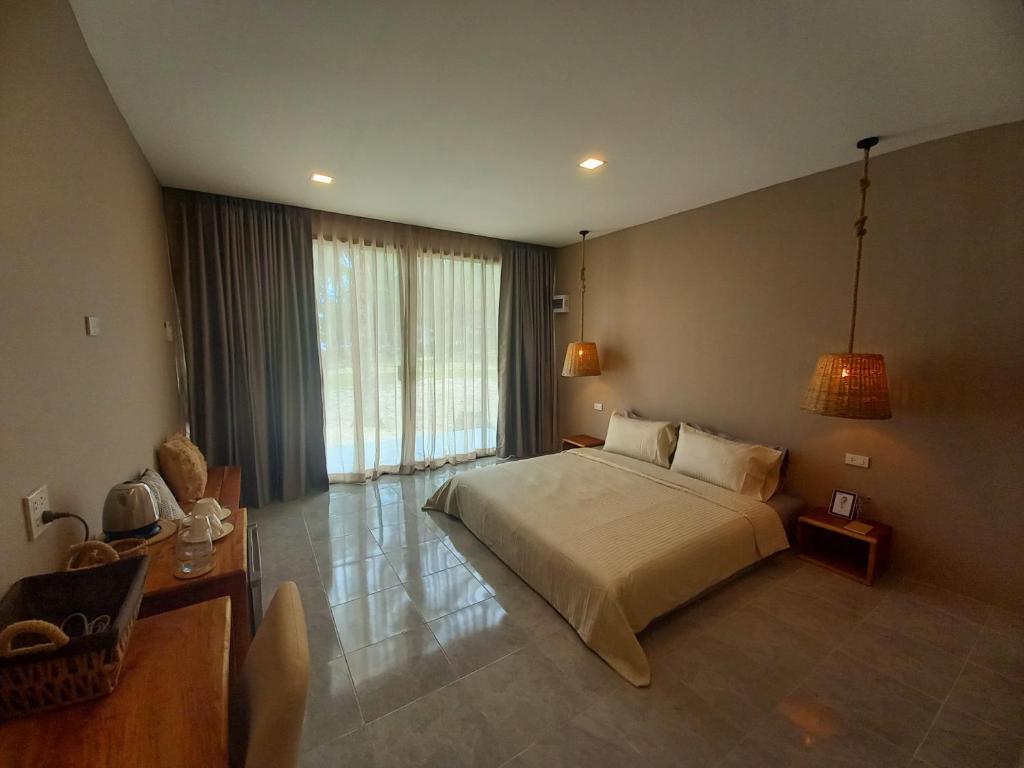 库德岛Koh Kood Club的一间卧室设有一张大床和一个大窗户
