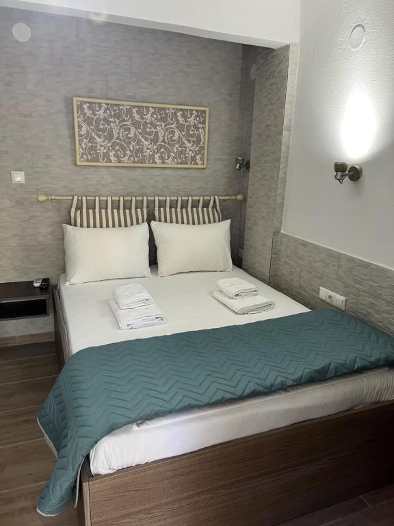 利迈纳里亚Grecian Sea的一间卧室配有一张大床和两条毛巾