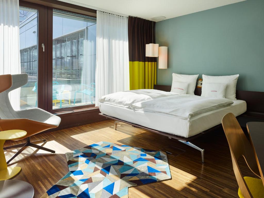 苏黎世苏黎世西区25时酒店的卧室配有床、椅子和窗户。