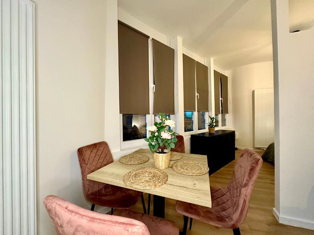 蒙斯Luxury Suites Mons的一间带木桌和椅子的用餐室