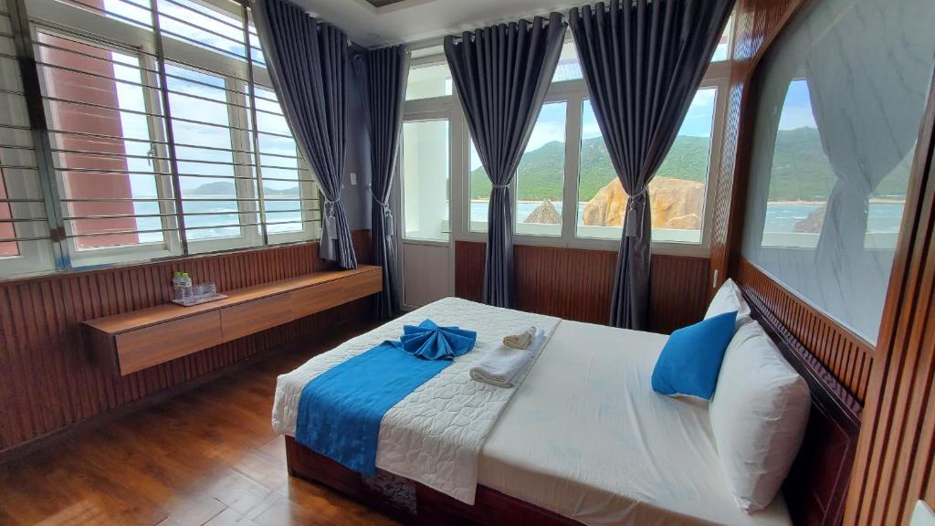 Thôn Thái AnKhu du lịch Hang Rái - Ninh Thuận的一间卧室配有一张蓝色弓床