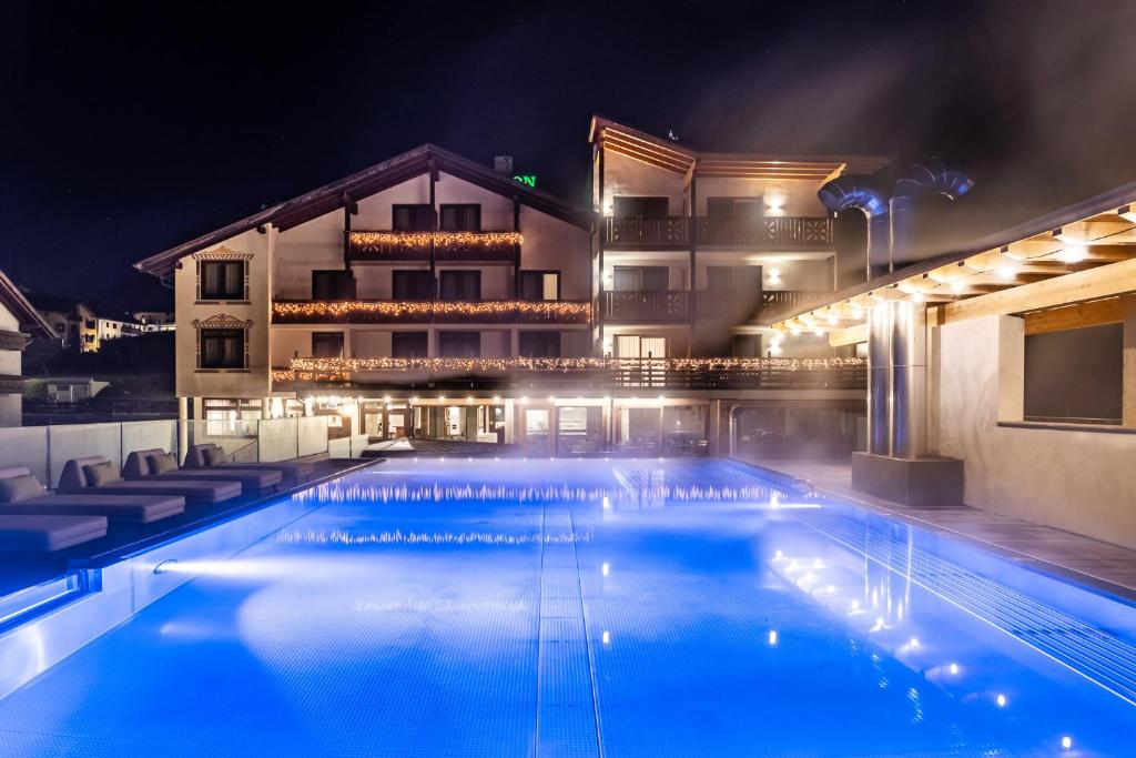 蒙克拉西科Hotel Ariston Garden & Spa的一个晚上的游泳池,酒店背景