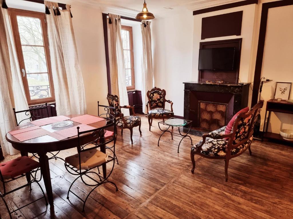 贝拉克Prestigieuse Résidence : N° 1 (2 chambres spacieuses)的客厅配有桌椅和壁炉