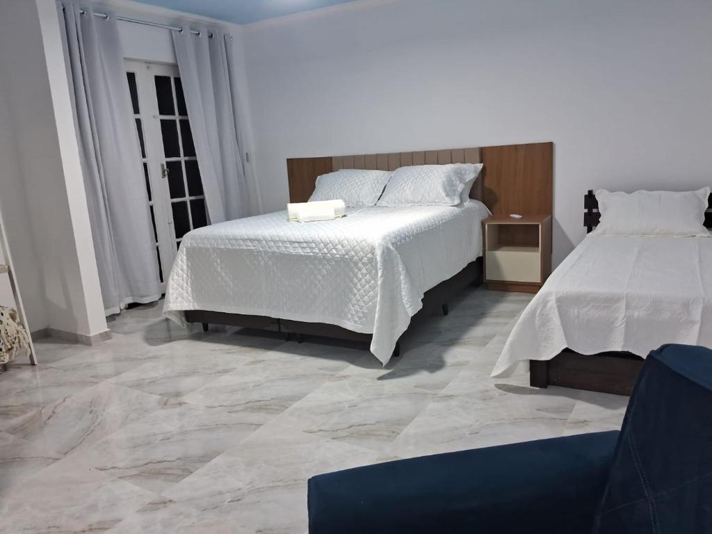 圣佩德罗-达阿尔德亚Pousada belo sol的一间带两张床的卧室,铺有瓷砖地板