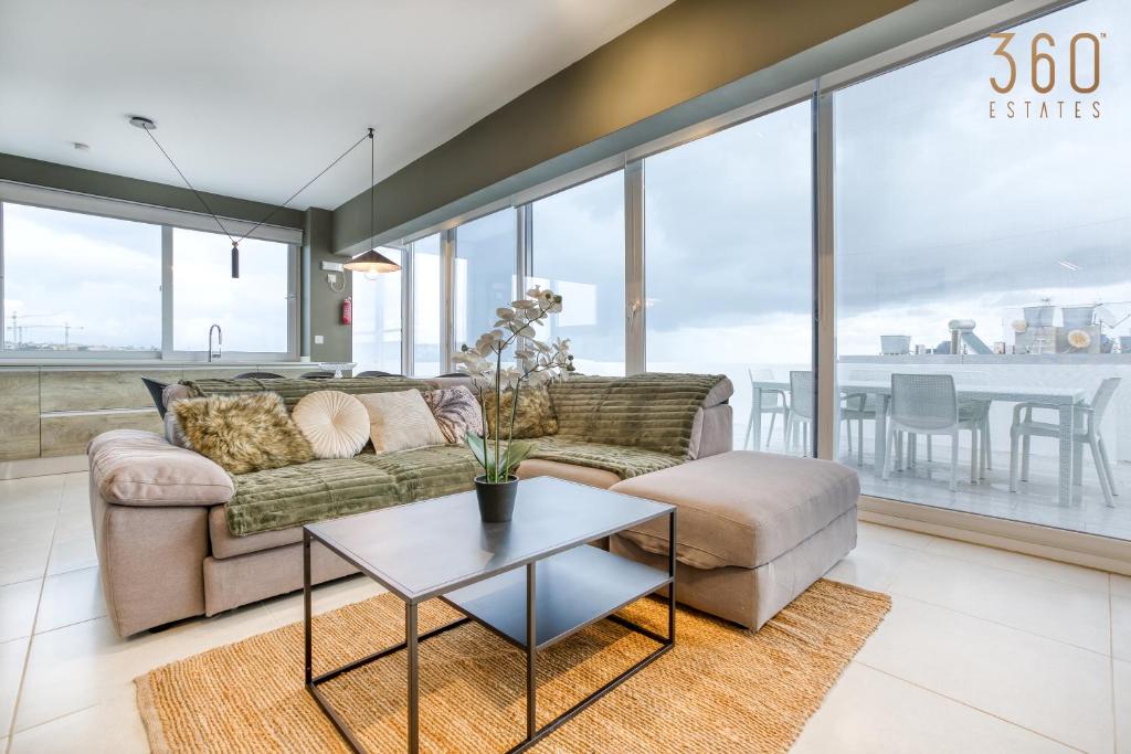 San ĠwannLUX Duplex Penthouse w/ Expansive Rooftop Terrace by 360 Estates的客厅配有沙发和桌子