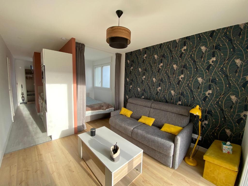 凯恩Appartement BIENVENUE au calme quartier Venoix的客厅配有沙发和桌子