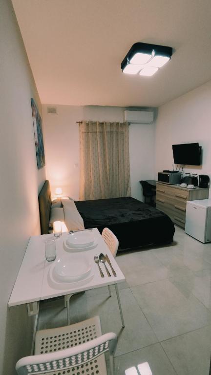 卢加Fairwinds - Double Room with Ensuite - Luqa Airport - Self Check In & Out available的卧室配有一张床和一张桌子及椅子