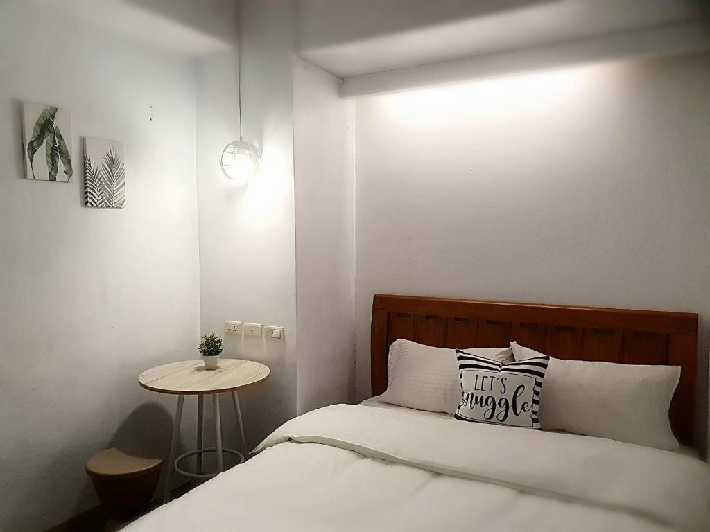 台北客憩旅宿的一间小卧室,配有一张床和一张桌子