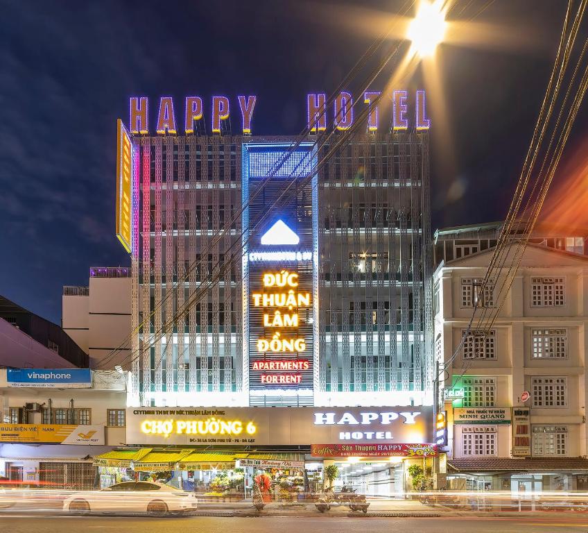 大叻Happy Dalat Hotel & Apartment的城市在晚上点燃,有快乐的新年标志