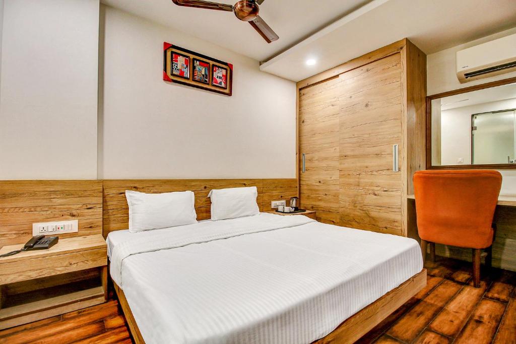 博帕尔FabHotel Manjeet的一间卧室配有一张床和一张桌子及椅子