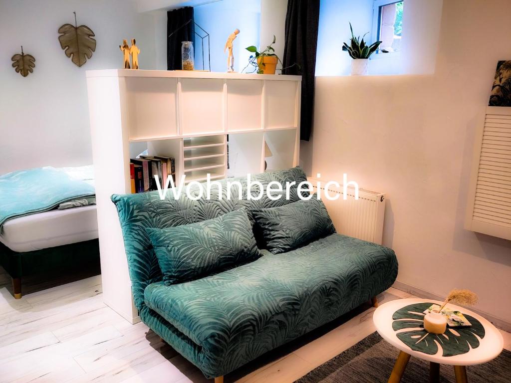 QuierschiedCasa Viva - Separate, ruhig gelegene Wohnung的客厅配有绿色沙发和床。