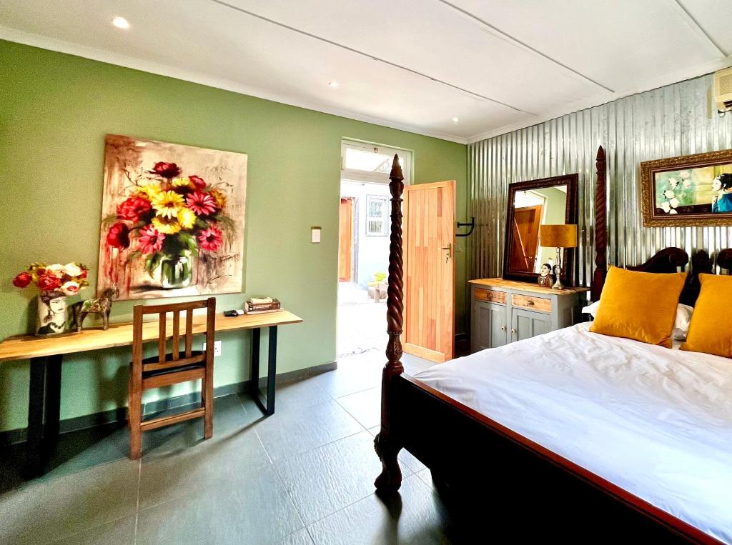 德班Terebinte Bed & Breakfast的一间卧室配有一张床和一张带花瓶的书桌