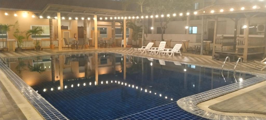曼谷Tèja Hotel的大楼内带桌椅的大型游泳池