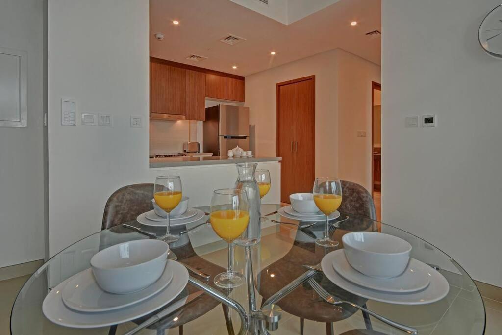 迪拜Beachwalk Luxury 2BR with Infinity Pool and Views的玻璃餐桌,配以橙汁