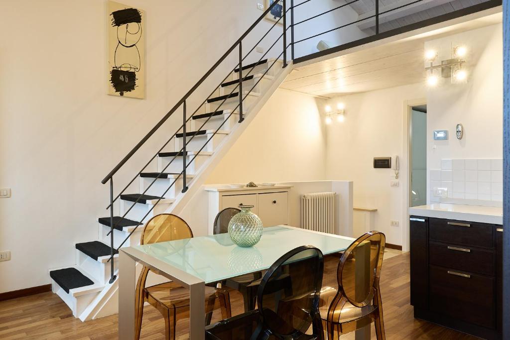 法诺Loft del Faro的一间带桌椅和楼梯的用餐室