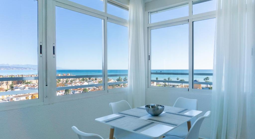 马拉加Septimo Cielo Vistas al Mar Guadalmar的一间设有一张桌子并享有海滩美景的用餐室