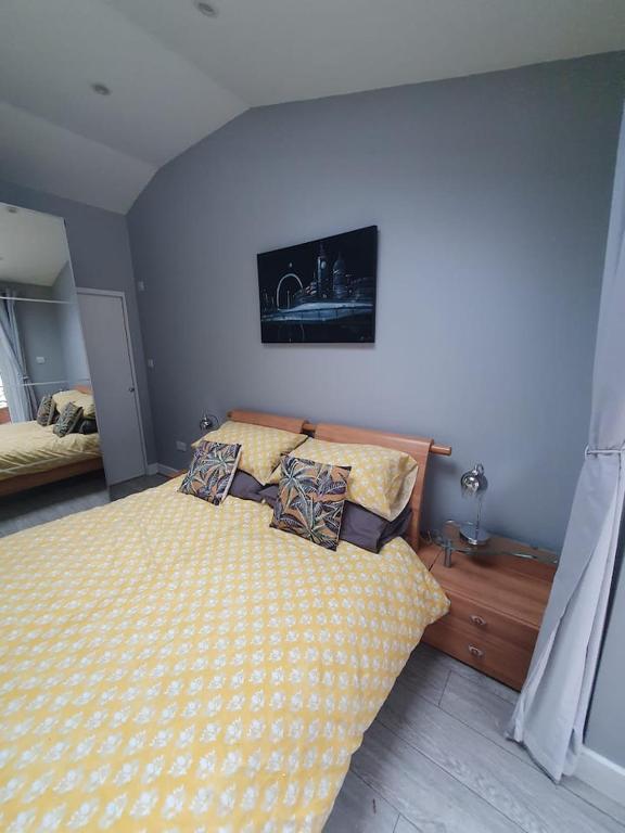 The HydeLovely double room with en-suite bathroom的一间卧室配有一张带黄色床单和枕头的床。