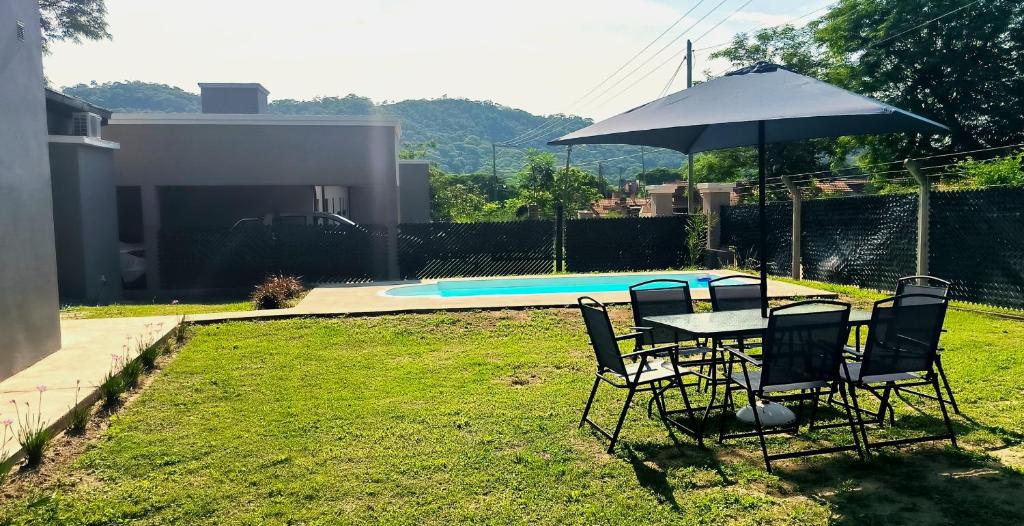 巴克罗斯Casa de los Cerros - Vaqueros的游泳池旁配有遮阳伞的桌椅