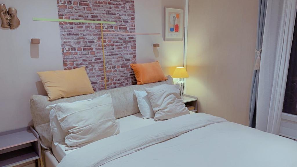 巴黎Cozy Paris Apartment的一间卧室设有一张床和砖墙