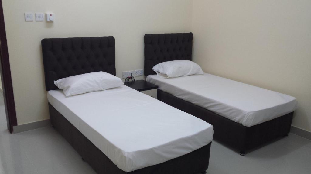 塞拉莱金四季带家具公寓的配有白色床单的客房内的两张床