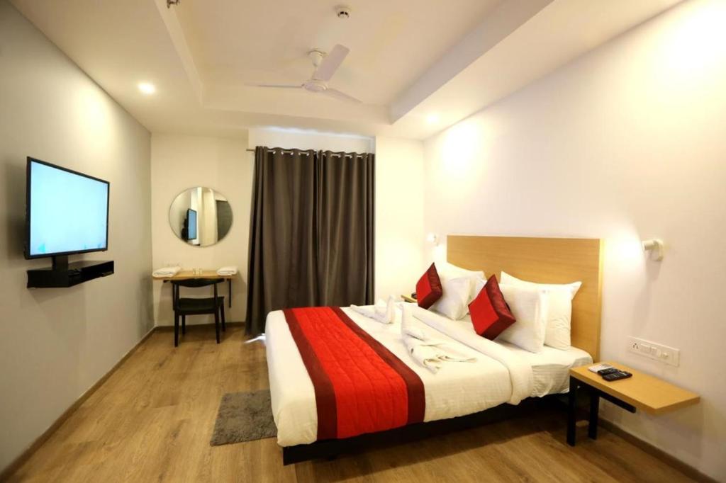 新德里Hotel Rudra Inn At Chattarpur的酒店客房,配有床和电视