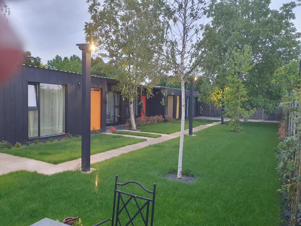 阿拉德Pensiune Arada的房屋前带长凳的绿色庭院