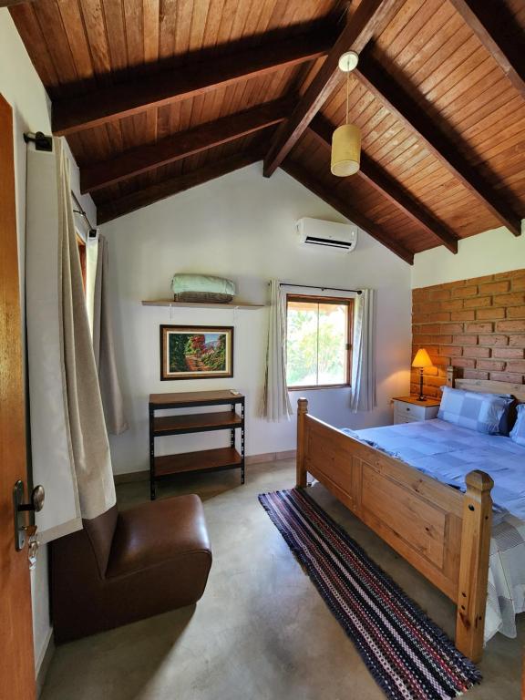 戈亚斯州上帕莱索Refúgio Tao Cerrado Chalé Pé de Serra的一间卧室设有一张床和木制天花板