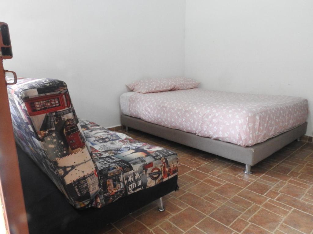 San Juan de AramaECOALDEA CURIA Lodge的一间卧室配有一张床,另一间卧室配有一张搁脚凳