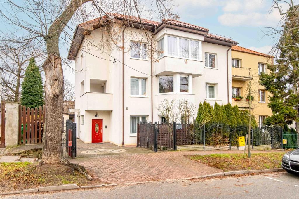 格丁尼亚Willa LTC Apartments Orłowo的一间红色门的白色房子