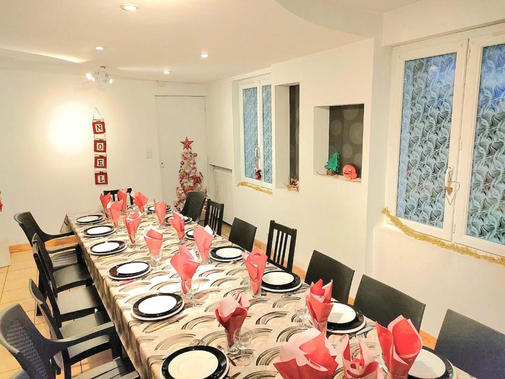 昂热L'auberge Angevine的一张长桌子,上面有红色的餐巾和椅子