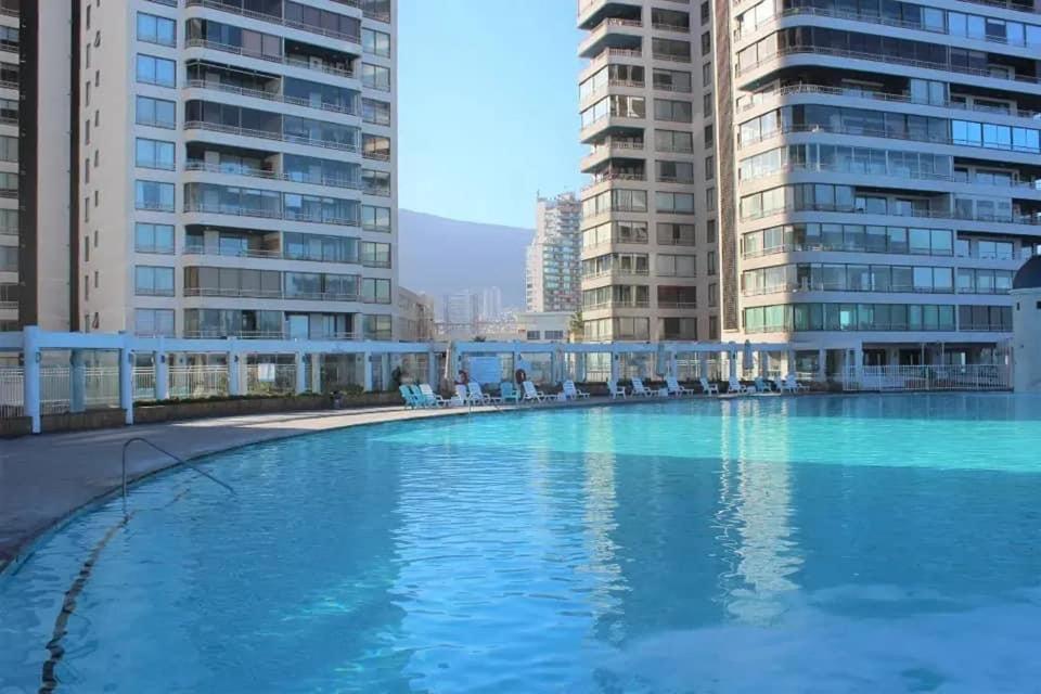 伊基克Frente a la Playa, amplio departamento para 10 personas, con 4 dormitorios y 4 baños的一座大型游泳池,位于部分建筑的中间