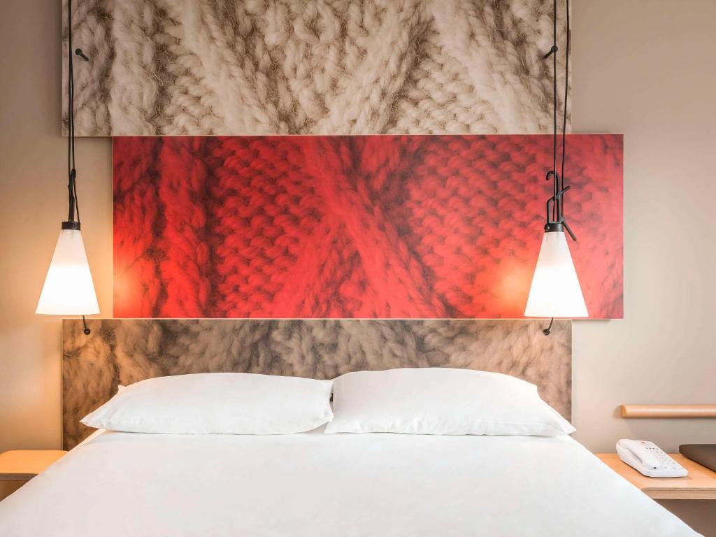 巴黎巴黎圣马丁运河宜必思酒店的一间卧室配有白色的床和两盏灯