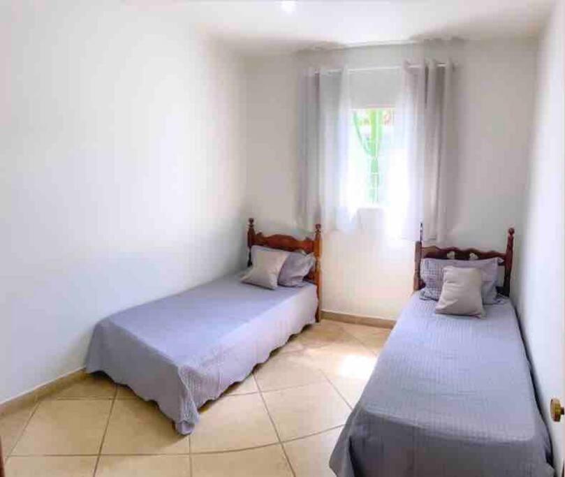 圣湖镇Casa na Orla de Lagoa Santa的白色客房的两张床,设有窗户