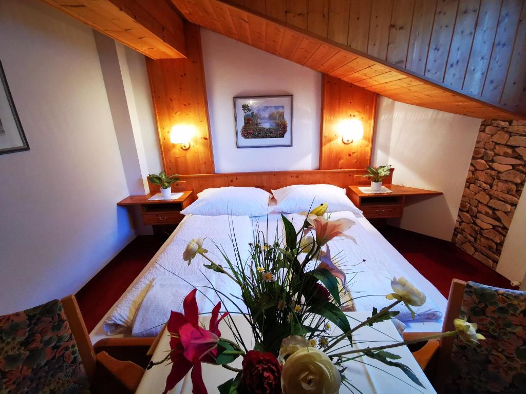 洛弗附近魏斯巴赫Gasthof Geronimo的一间卧室配有一张床和一张鲜花桌子